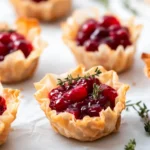 Cranberry-filled phyllo cups with fresh herbs, a perfect Thanksgiving appetizer.