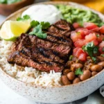 a bowl of food with meat and limes